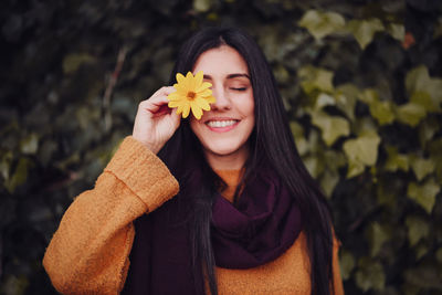 Portrait of a smiling young woman holding flower