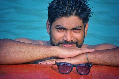 Portrait of handsome young man in swimming pool