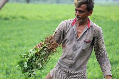 Mid adult man holding ice cream on field