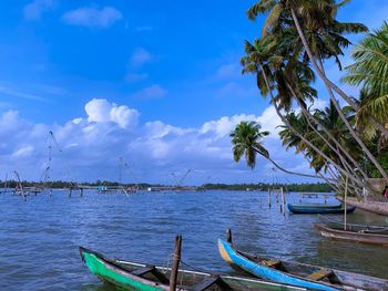 Sailboats moored in sea against sky