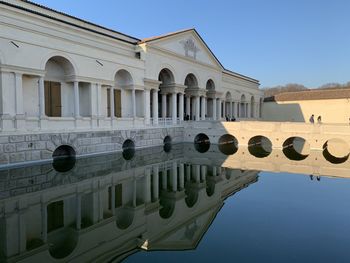 Reflection of building in water against clear sky