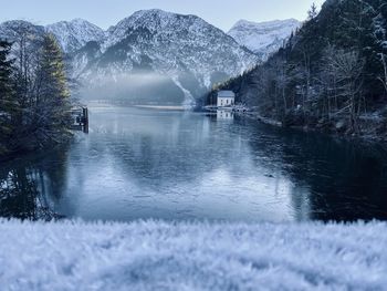 Scenic view of lake by snowcapped mountains during winter