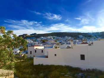 Buildings in town against cloudy sky