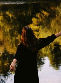 Rear view of woman standing in lake