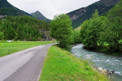 Road amidst green landscape against sky