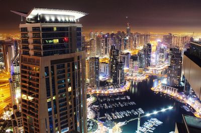 Illuminated modern buildings against sky in dubai marina at night