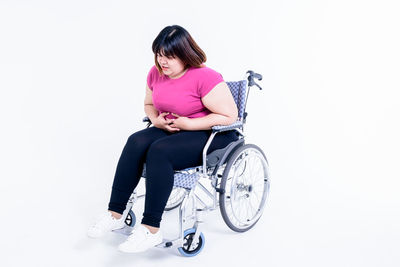 Portrait of woman sitting against white background