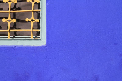 Cropped image of window on purple wall