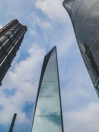 Low angle view of modern building against cloudy sky