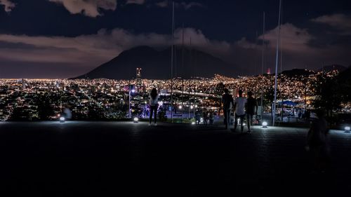 Illuminated city against sky at night