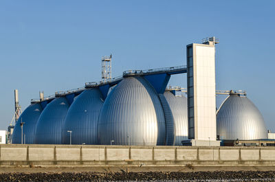 View of factory against clear blue sky