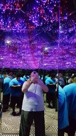 People photographing illuminated christmas lights at night