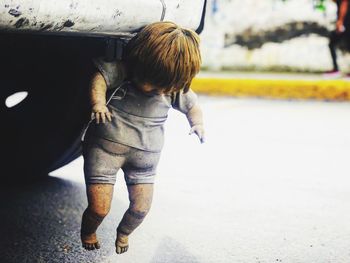 Doll hanging on vehicle at road