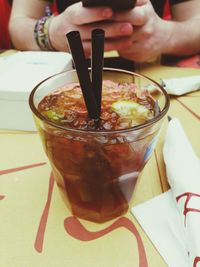 Close-up of hand holding ice cream on table