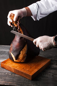 Midsection of man preparing food on cutting board