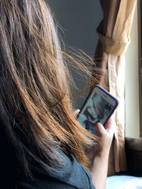 Woman taking selfie while sitting at home