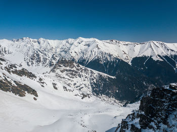 Scenic view of snowcapped mountains against clear blue sky