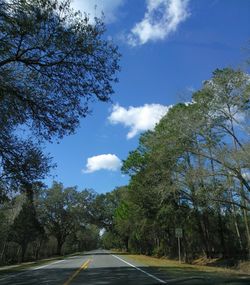 Road amidst trees against sky