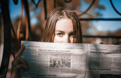 Close-up portrait of young woman reading book