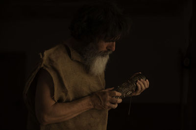 Man looking at camera while standing against black background