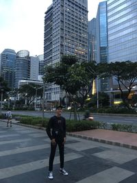 Full length of man and modern buildings in city