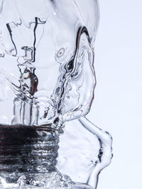 Close-up of water drop on glass against white background