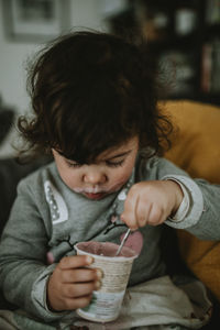 Midsection of a child eating yogurt