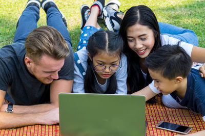 Happy family using laptop at park