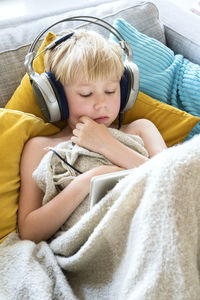 Boy using digital tablet on sofa