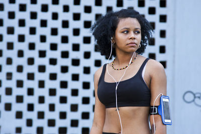 Side view of young woman standing in gym