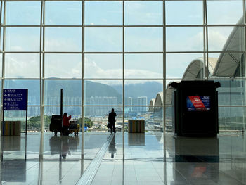 People waiting at airport against sky