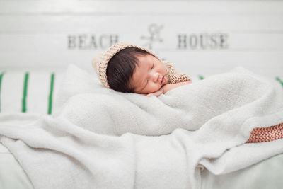 High angle view of baby sleeping on bed