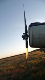 Airplane on field against sky during sunset