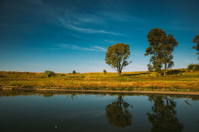 Scenic view of lake against sky at night