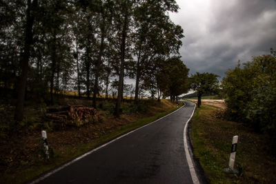 Road amidst trees against sky