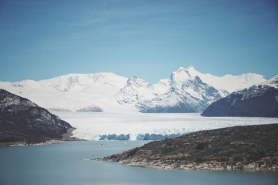 Scenic view of snowcapped mountains and sea against sky