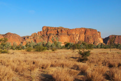 Rock formations on landscape against blue sky