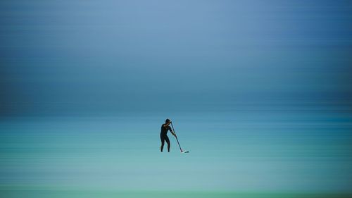 Man in sea against sky