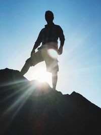 Low angle view of silhouette man against sky on sunny day