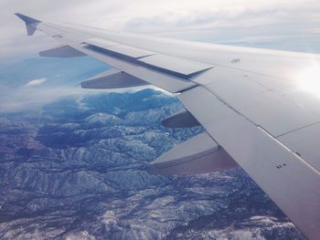 Cropped image of airplane wing over landscape