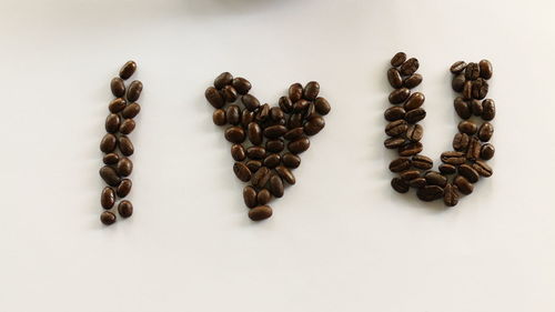 High angle view of coffee beans against white background