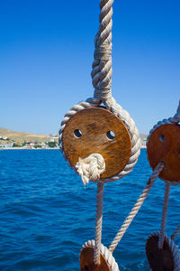 Close-up of wooden post in sea against clear blue sky