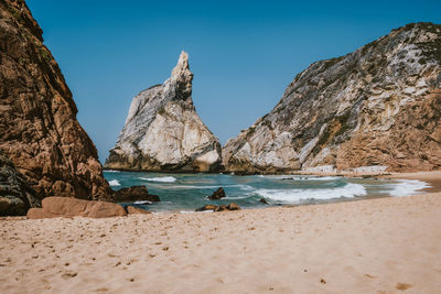 Scenic view of sea and mountains against clear blue sky