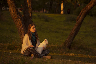 Young woman with dog siting in park. tranquility, conciliation, digital detox, reconnecting nature