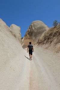 Rear view of man riding motorcycle on desert