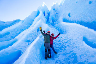 Panoramic view of people walking on snow covered mountain