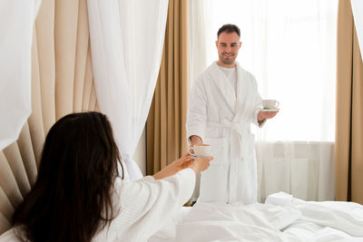 Couple with coffee cups in hotel room