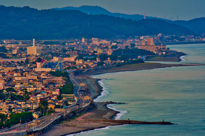 High angle view of townscape by sea against sky