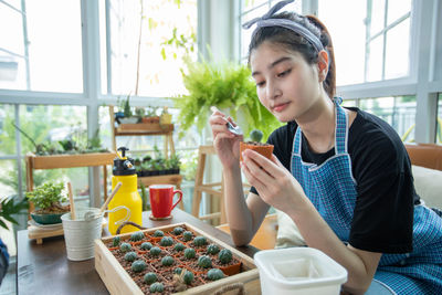 Young botanist sitting in greenhouse