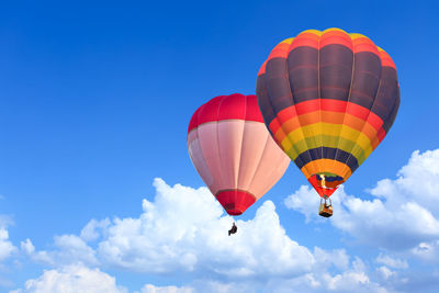 Low angle view of hot air balloons against blue sky